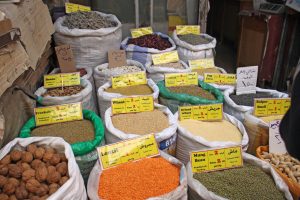 Open sacks of grains and beans displayed for sale at a souk