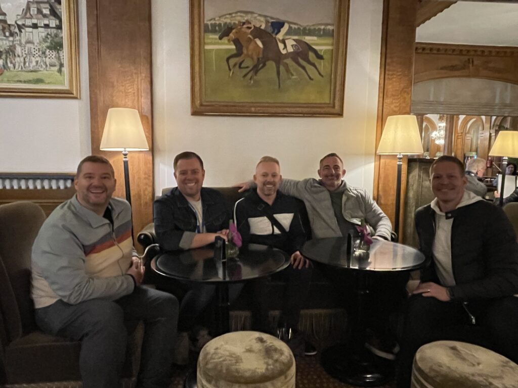 four friends sitting down and smiling