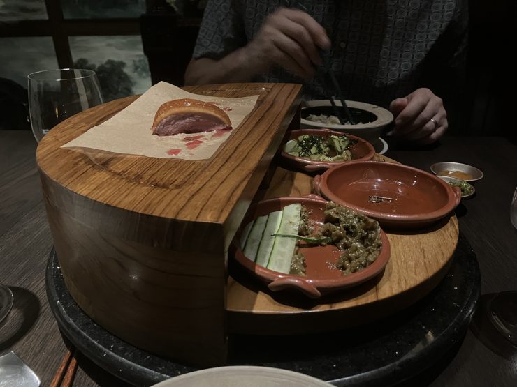 Duck meat on a rotating plate with condiments.