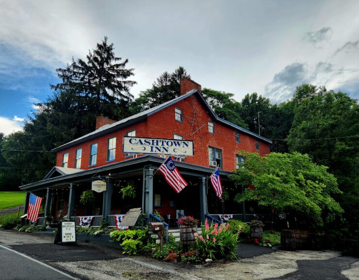 Beautiful brick 4-story Cashtown Inn with old growth trees surrounding it.