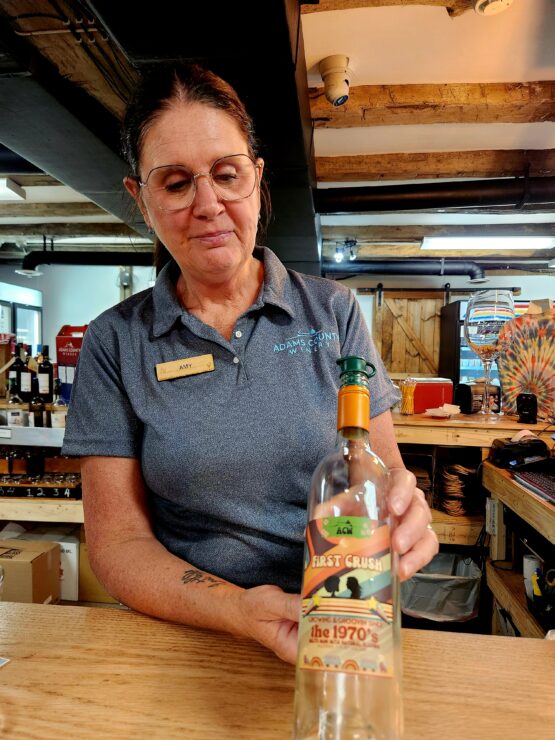 Amy, at Adams County Winery, shares one of their bottles of wine.