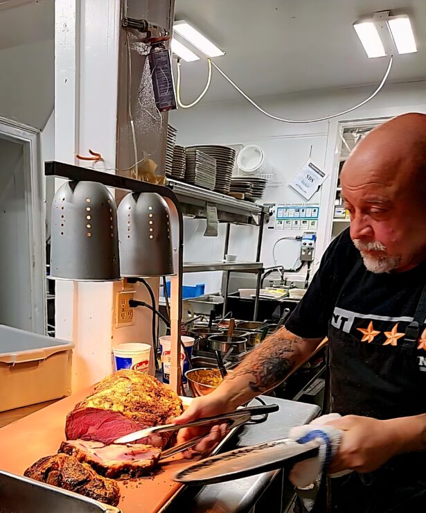 The chef in the Cashtown Inn kitchen, carving a prime rib.