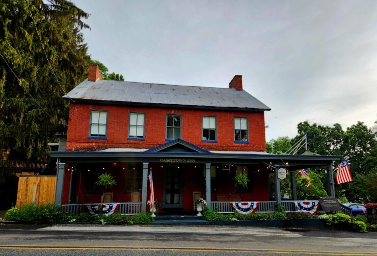 Photo of the Cashtown Inn showing its red facade and front porch from across the street
