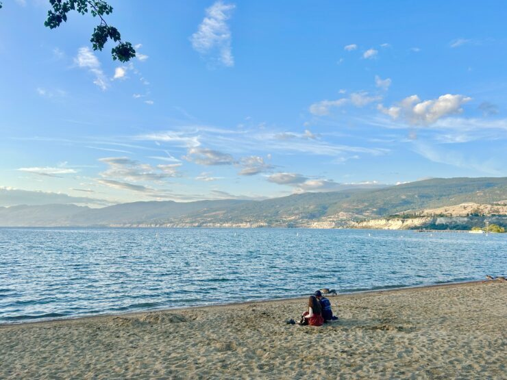 Okanagan Lake shoreline with mountains, a must-visit Penticton travel spot.