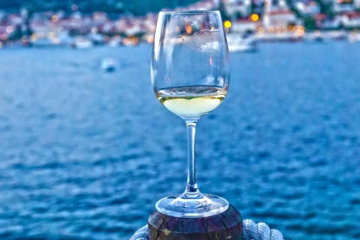 Glass of white wine against a backdrop of the Adriatic Sea.