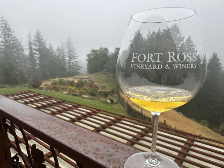 Glass of Fort Ross chardonnay on patio overlooking garden 