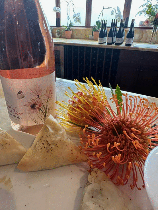 A bottle of Fort Ross Rose of Pinot Noir on bar with Protea flowers