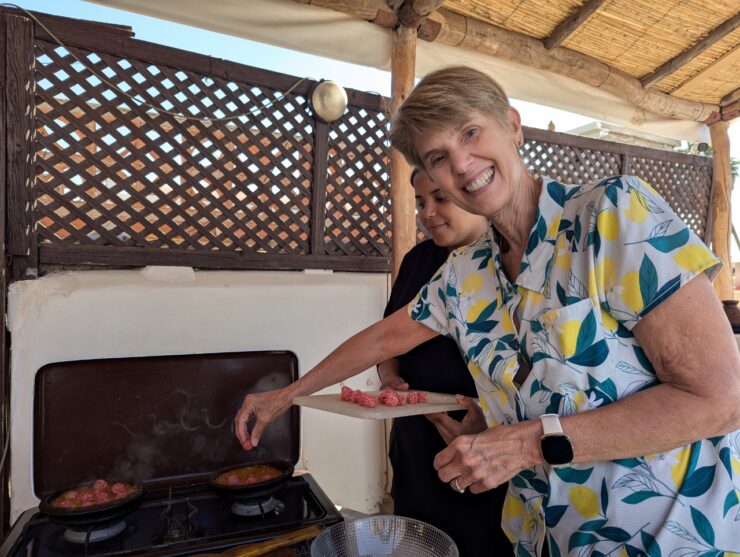 Author drops meatballs into tagine stew.
