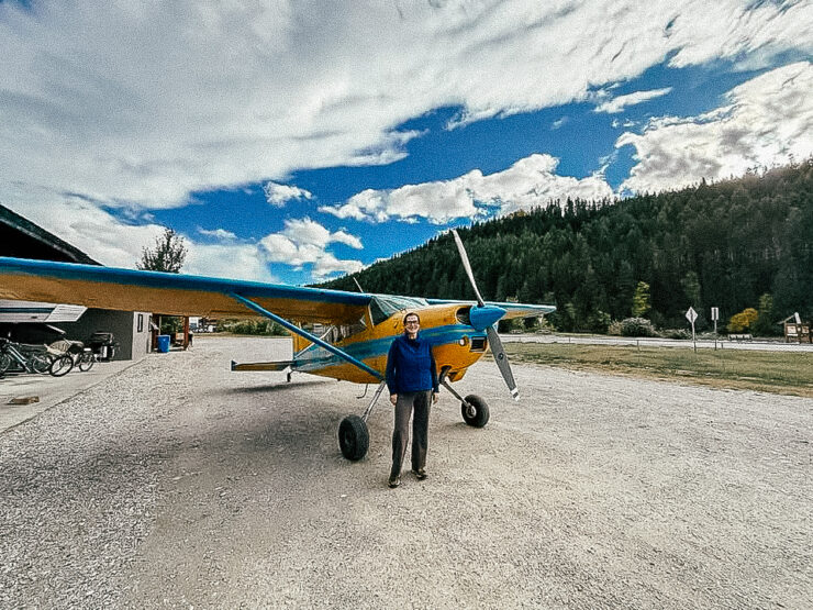 Woman standing in front of blue and yellow Cessna