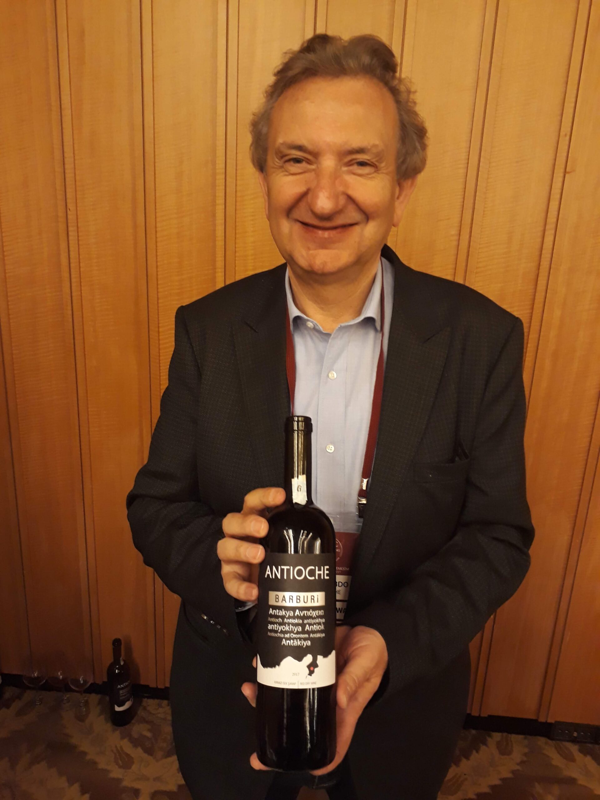 smiling man displaying a wine bottle