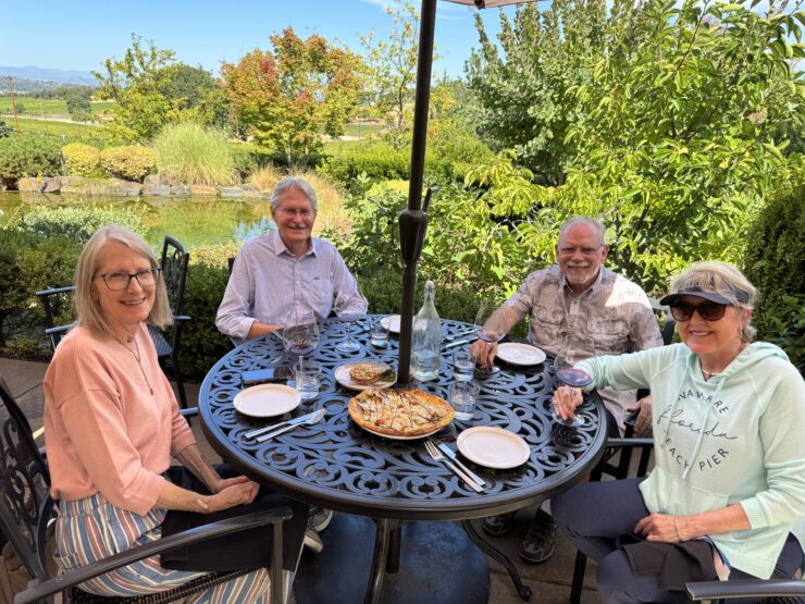 Group of four at a table on the patio at DANCIN Vineyards, ready to eat a pizza for lunch.