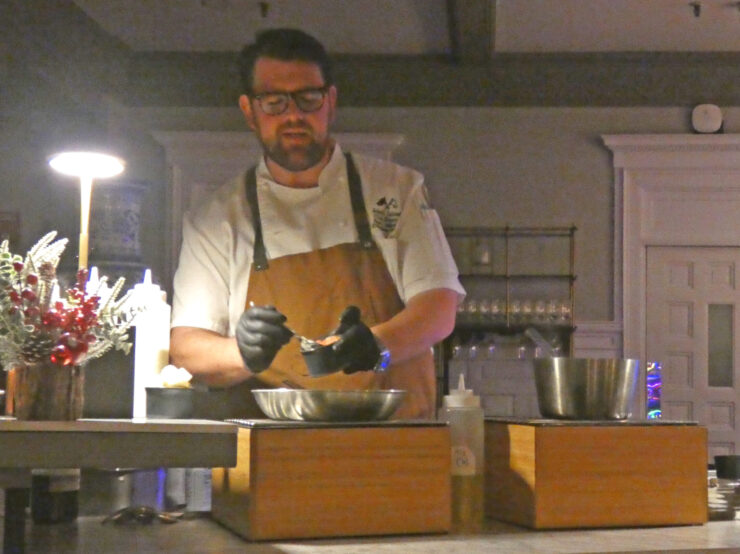 Chef Ryan Caldwell demonstrating making shrimp and grits.