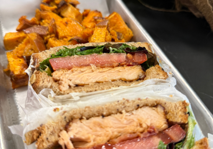 Salmon sandwich with sweet potatoes on the side. 