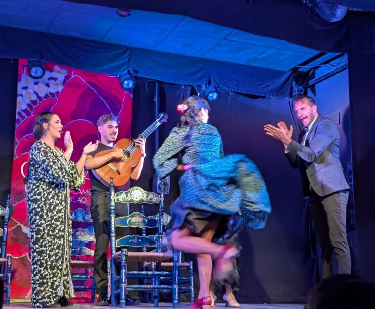 Four flamenco performers on a stage: two dancers, one musician and one vocalist. 