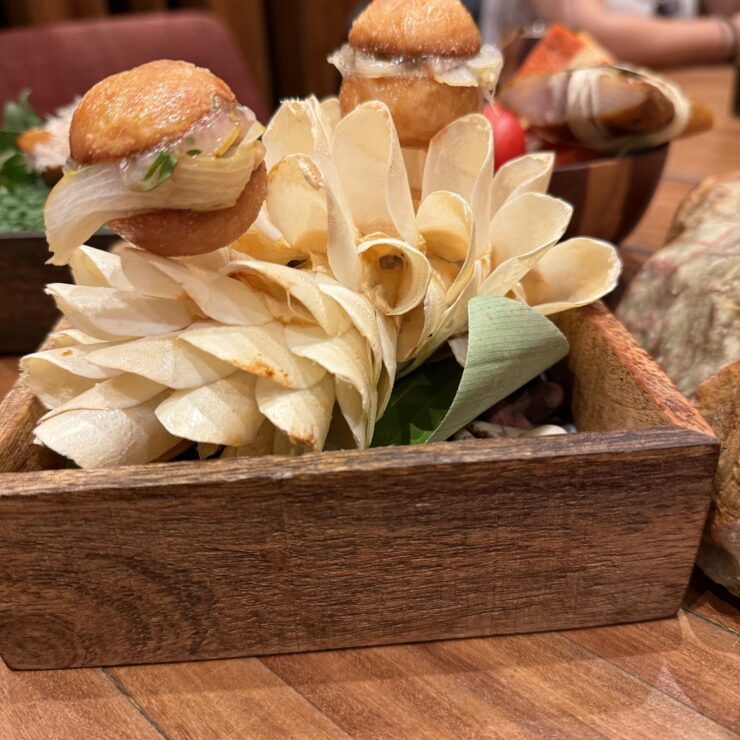 Smoked paiche sandwiches at Maido, made from a Amazon river fish, are served on a stand of thumbnail-sized paiche scales.