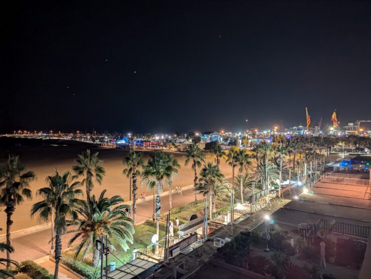 Nighttime scene of broad expanse of beach brightly lit 