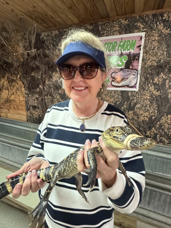 The writer holding a baby gator for a photo opportunity.