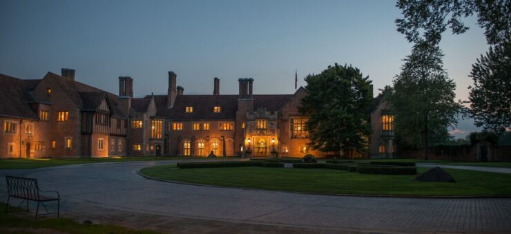 A view of Meadow Brook Hall at night with lights shining