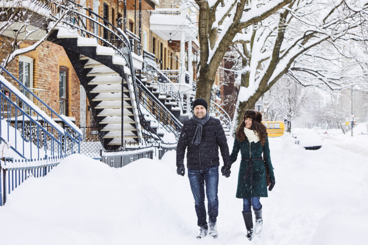 A couple walks down a snowy sidewalk in residential Montreal. ©Madore Maude Chauvin Tourisme Montreal