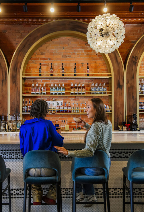 Two people socializing at the bar in the Ypsi Cocktail Club