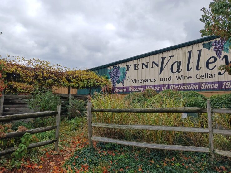 Fenn Valley Vineyards building with plants, vines, and a wooden fence in the foreground