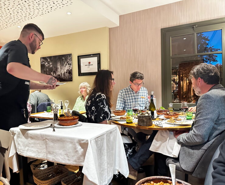 waiter in restaurant serves patrons cassoulet