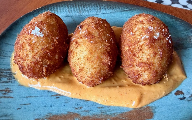 Croquettes based on bechamel made with cheese and serrano ham, deep fried.