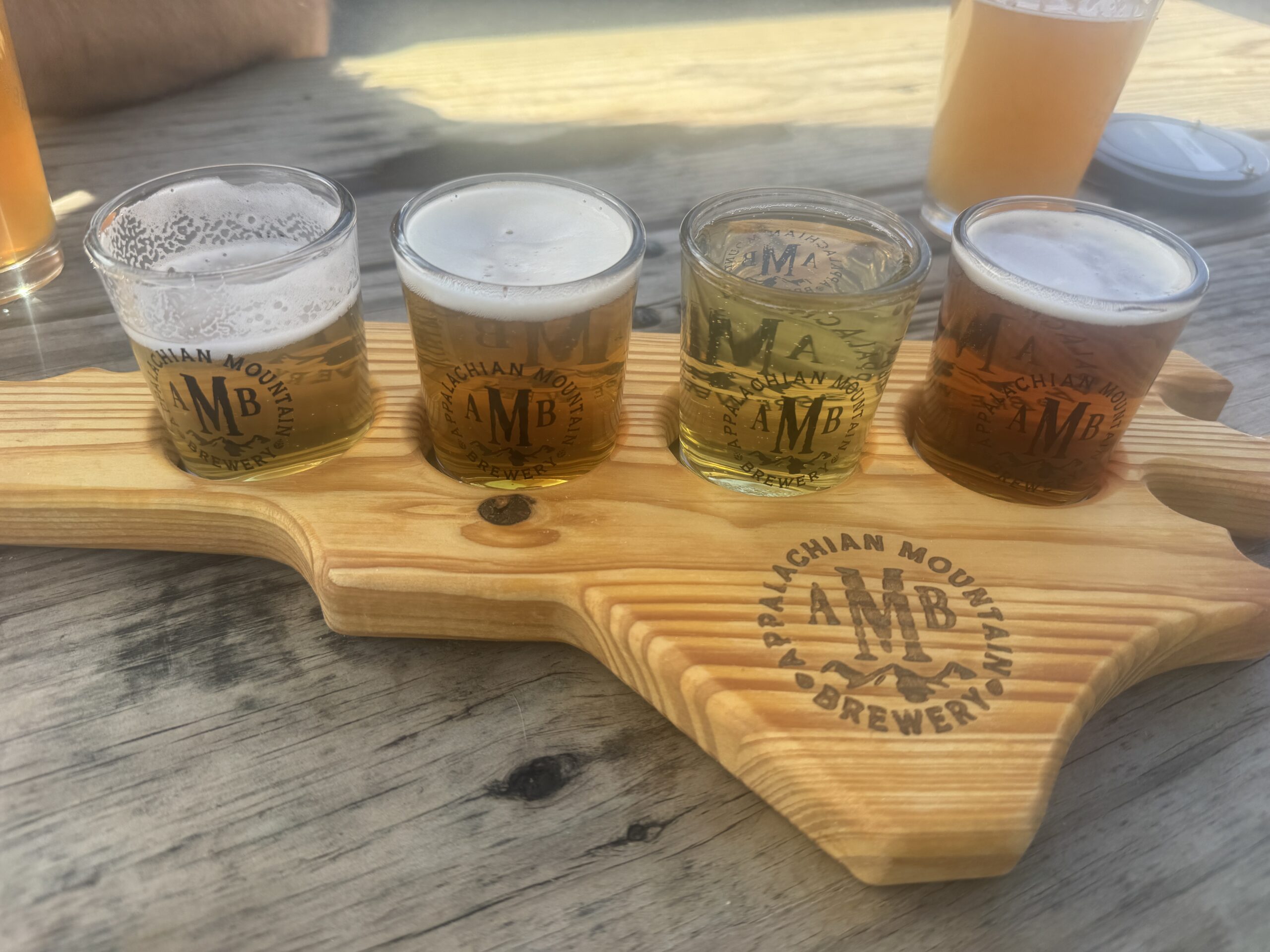 Small beer glasses in a wooden holder in the shape of North Carolina