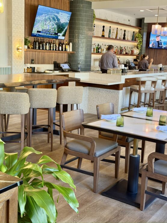 Conquistador restaurant dining room with tables, chairs, bar seating, and colorful wall art at Mission Resort + Club in Howey-in-the-Hills, Florida.