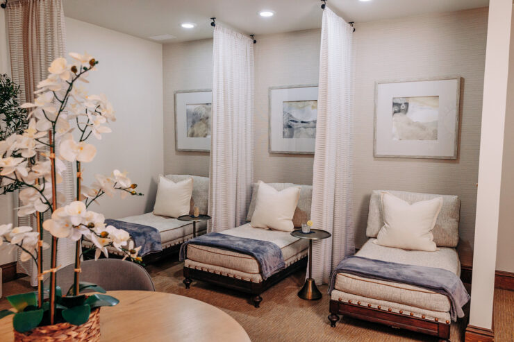 Ladies’ lounge at The Spa at Mission Resort + Club with upholstered chairs, soft lighting, neutral décor, framed artwork, and floral accents.