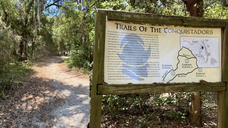 Trails of the Conquistadors sign along a wooded walking path at Mission Resort + Club in Howey-in-the-Hills, Florida.