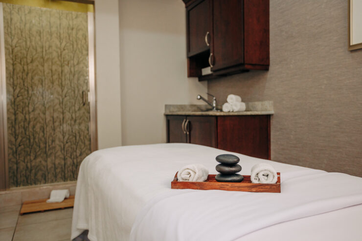 Spa treatment room at Mission Resort + Club with a massage table, soft lighting, neutral décor, and calming spa details.