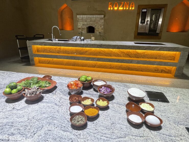 flavors of Oman - turmeric, shallots, tomatoes, limes, sardines, rocket leaves and chili flakes are placed in bowls on the counter