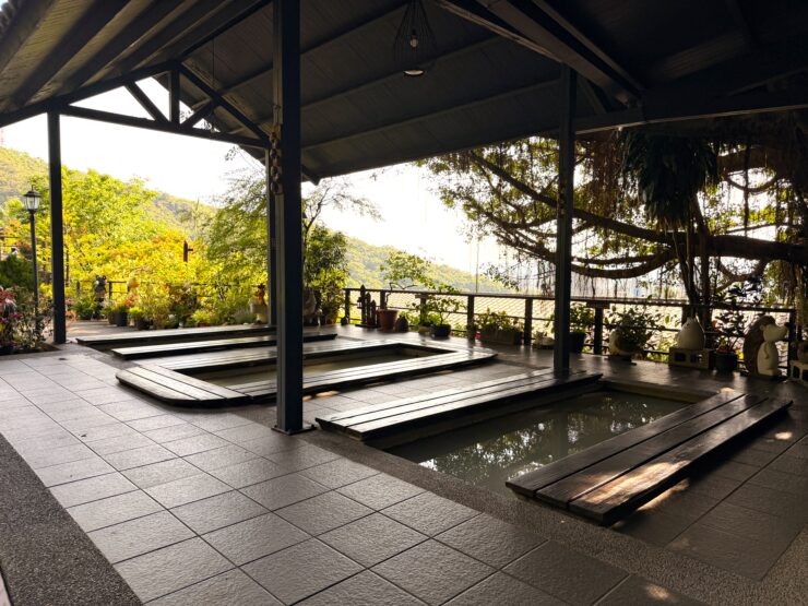 Foot baths with wooden planks for seating around the edge. Under a covered pavilion