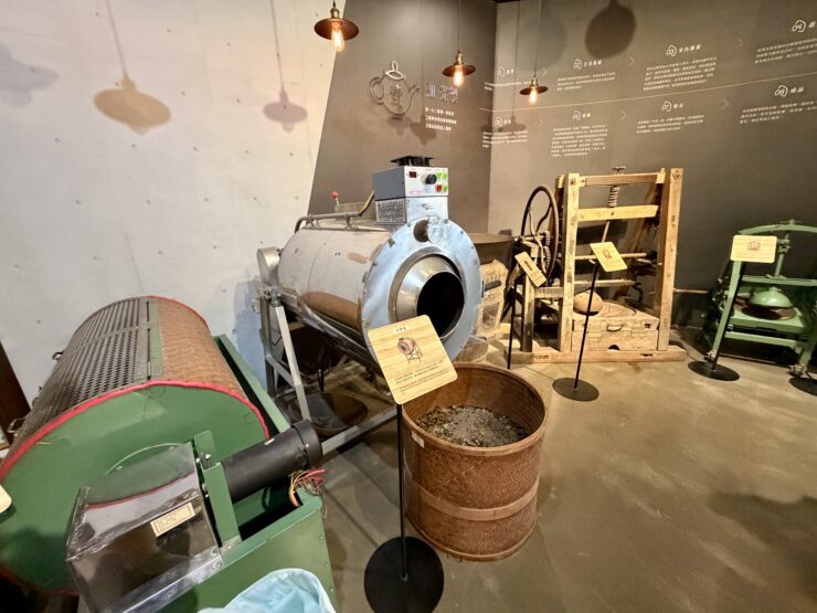 A museum display of various machines used in the production of tea with interpretive signs.