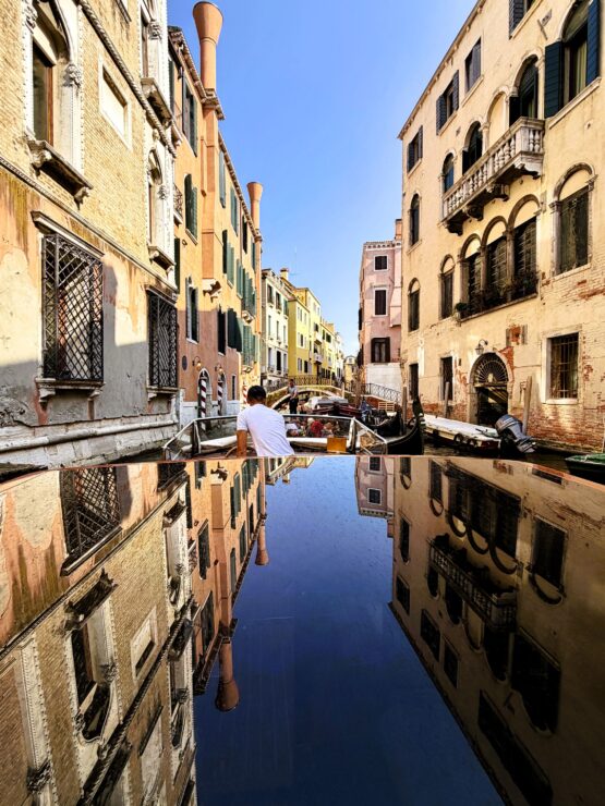 Water taxi in Venice with reflection building on the roof