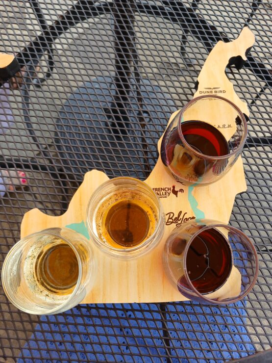 Wooden board shaped like northern Michigan holding four wine glasses