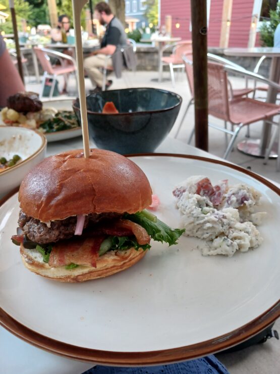 plate holding a burger and potato salad at Gilchrist Farm Winery